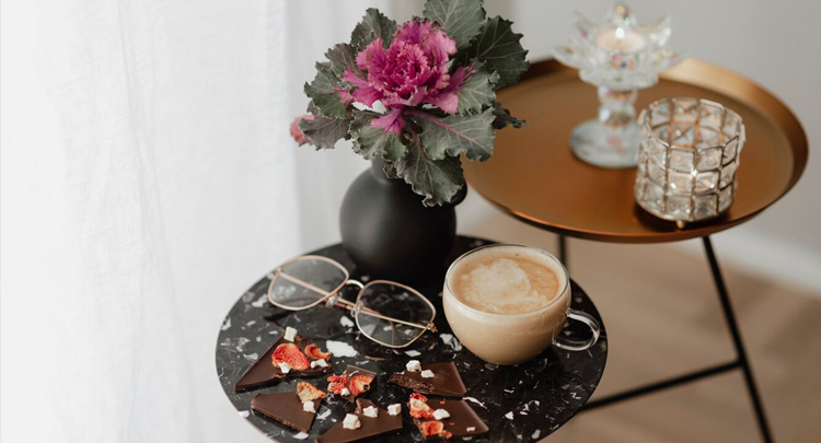 Cup-of-milk-tea-and-eyeglasses-on-a-black-table-next-to-a-curtain-body-3